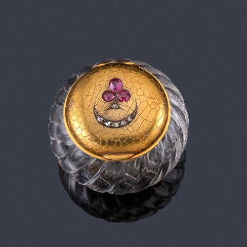  Cajita de rapé realizado en crista de roca gallonado con tapa en oro amarillo de 18K texturizado y decorado con diamatnes talla rosa y rubíes talla oval. S. XIX, París.