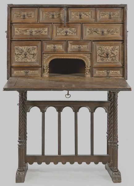  Escritorio de talla plateresca, renacentista y figurada en madera de nogal, con una tapa frontal abatible lisa con cerradura de hierro recortado. Corona de Aragón, mediados S. XVI