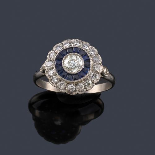  Anillo 'ojo de perdiz' con brillante central de aprox. 0,40 ct con doble orla de brillantes y zafiros calibrados.