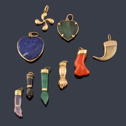  Lote con cinco higas realizadas en gemas duras, dos corazones con jade y lapislázuli, un colmillo y colgante en oro amarillo de 18K.