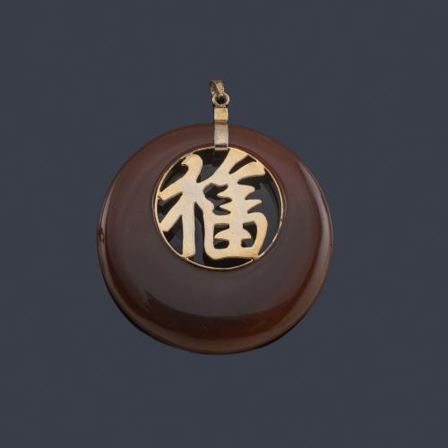 Lote 2128
Colgante con centro de sinograma asiáticos en metal dorado enmarcado en pieza de carneola pulida.