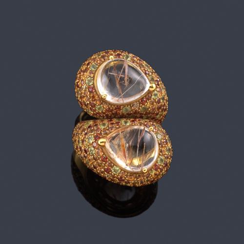  LUIS GIL
Anillo con brazos contrapeados con pareja de cuarzos rutilados en cabujón con montura bombé cuajada de zafiros naranjas y amarillos, en oro amarillo de 18K.