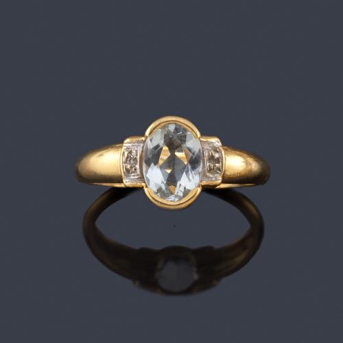  Anillo con aguamarina talla oval y dos diamantes sobre montura de oro amarillo de 18K.
