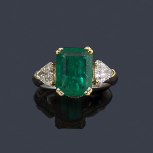  Anillo con esmeralda central de aprox. 3,53 ct con dos diamantes talla triángulo de aprox. 0,40 ct cada uno.