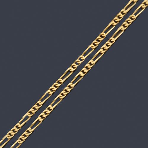  Cadena larga con eslabones barbados en montura de oro amarillo de 18K.