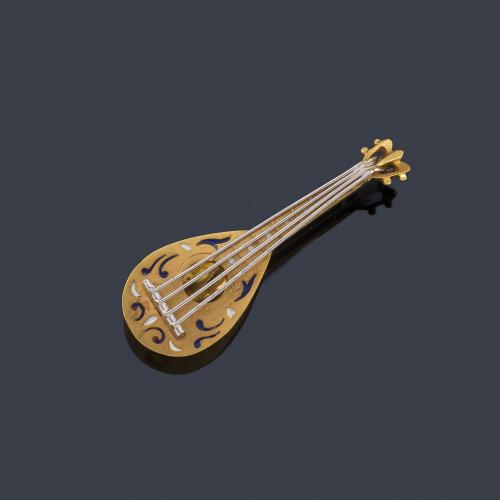 Broche con diseño en forma de bandurria con detalles en esmalte, realizado en montura de oro amarillo y blanco de 18K.