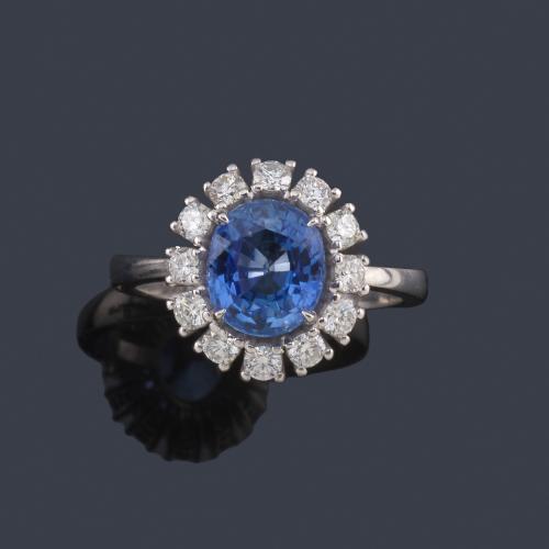  Anillo con zafiro talla oval de aprox. 2,47 ct con orla de brillantes de aprox. 0,60 ct en total.