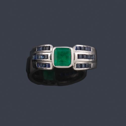  Anillo con esmeralda central de aprox. 0,50 ct con tres bandas de zafiros calibrados en ambos lados.