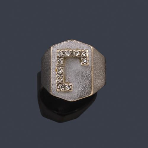 Lote 2428
Anillo tipo sello con letra 'J' en diamantes talla sencilla en montura de oro blanco mate de 18K.