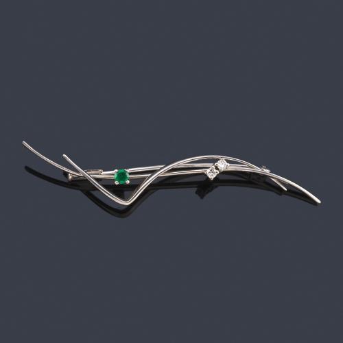  Broche con dos cintas onduladas con una pareja de brillantes y una esmeralda engastadas en garra.