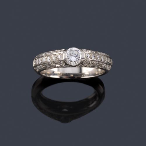  Anillo con brillante de 0,38 ct con tres bandas de brillantitos en ambos lados.