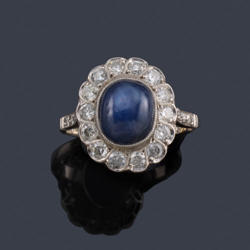  Anillo con zafiro estrella talla cabujón con orla de brillantes.