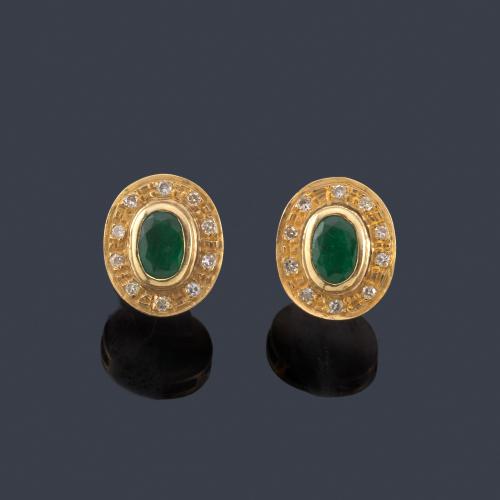  Pendientes cortos con pareja de esmeraldas talla oval y orla de brillantes.