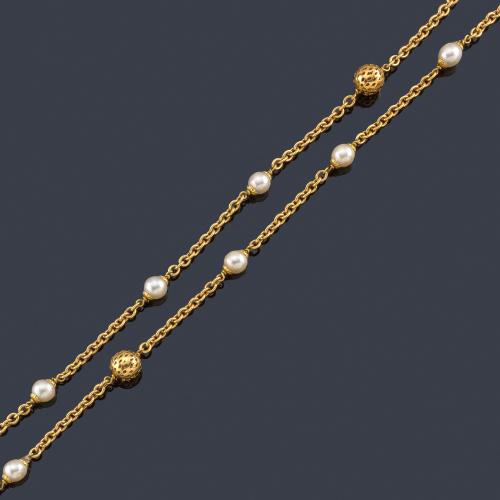  Collar largo con perlas y dos motivos esféricos con diseño calado, realizado en oro amarillo de 18K.