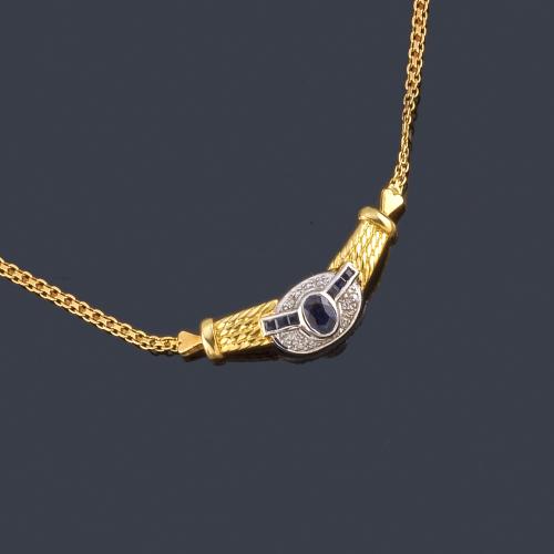  Collar con zafiro central talla oval y calibrados en ambos lados con brillantes sobre oro blanco de 18K, en montura y cadena de oro amarillo de 18K.
