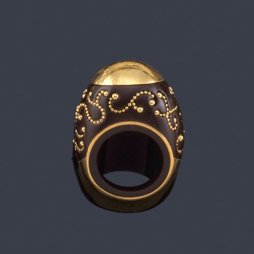  Anillo bombé con motivo semicircular en la parte superior en oro amarillo, en montura de madera de ébano con decoración de bolitas curvadas de oro amarillo de 18K.