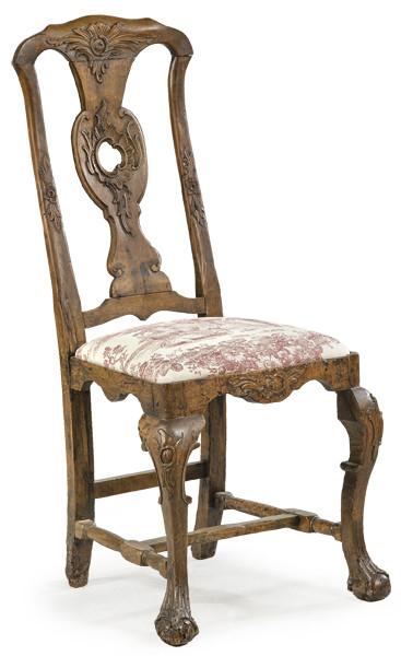  Silla siguiendo modelos ingleses del S. XVIII en madera de nogal tallada, con motivos de hojas y roleos. Respaldo calado y recortado, con patas unidas por chambrana en H. España, S. XVIII