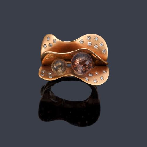 Lote 2127
Anillo con diseño ondulado con brillantes y dos cuarzos esféricos facetados en montura de oro rosa mate de 18K.