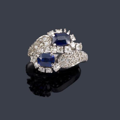  Anillo con dos zafiros talla oval con dos brazos contrapeados cuajados de brillantes.