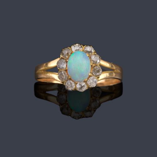  Anillo con ópalo central y orla de diamantes talla antigua en montura de oro amarillo de 18K.