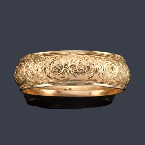  Pulsera ancha con motivos vegetales cincelados en oro amarillo de 18K.