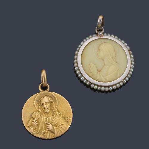  Lote con dos medallas devocionales, una con La Imagen de La Virgen realizada en hueso y orla de perlitas en montura de oro blanco y otra en oro amarillo de 18K.
