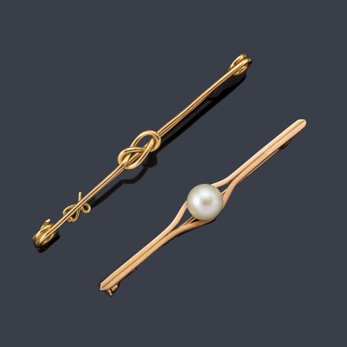  Dos alfileres uno de ellos con una perlita central y otro con motivo de nudo, realizados en oro amarillo de 18K.