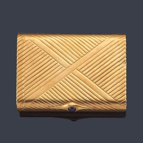  Pitillera en oro amarillo de 18 K con decoración rayada y cierre con zafiro cabujón.
