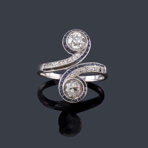 Lote 2076
Anillo 'tu y yo' con pareja de diamantes talla antigua de aprox. 0,35 ct cada uno con doble orla de zafiros calibrados y diamantes talla sencilla.