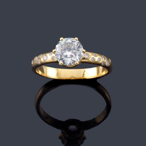  Solitario con un brillante de aprox. 1,06 ct en montura de oro amarillo de 18K salpicada con brillantes de aprox. 0,10 ct en total.