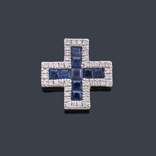  Cruz con zafiros calibrados y orla de brillantes en montura de oro blanco de 18K.