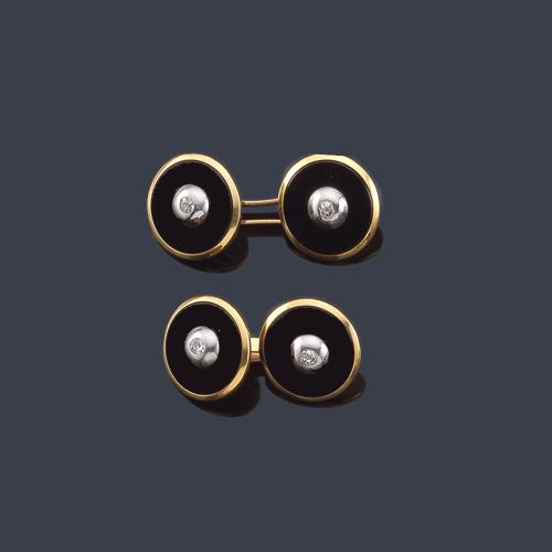  Gemelos con diseño circular con pieza de ónix y diamante central en montura de oro amarillo de 18K.