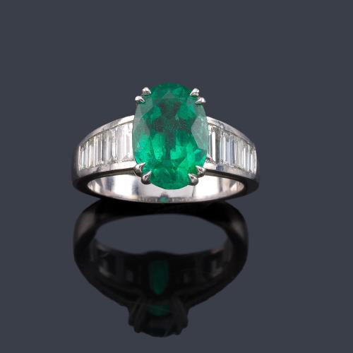 Lote 2214
Anillo con esmeralda talla oval de aprox. 3,36 ct con banda de diamantes talla baguette de aprox. 1,05 ct en total. Certificado Bellerophon Gemlab.