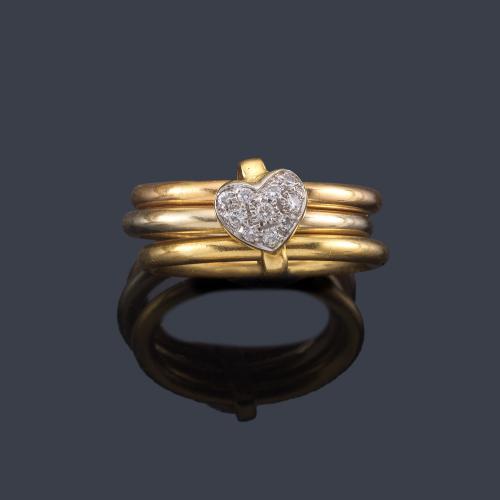  Anillo con detalle en forma de corazón con brillantes en montura de tres aros de oro amarillo de 18K.