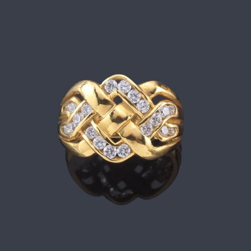  Anillo bandas entrelazadas de piedras incoloras en montura de oro amarillo de 18K.