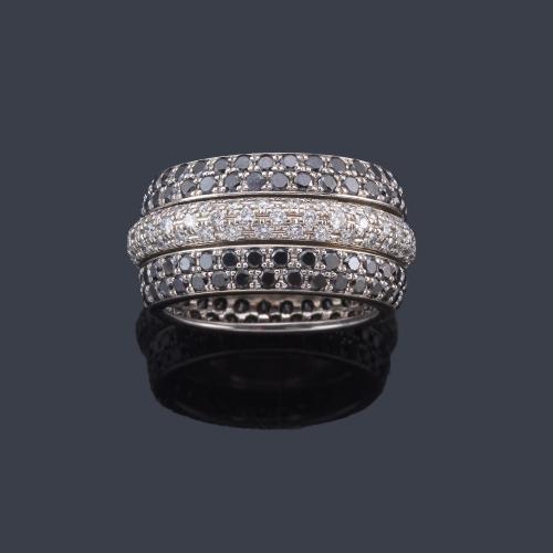  Anillo con tres bandas de diamantes incoloros y negros desmontables en montura de oro blanco de 18K.