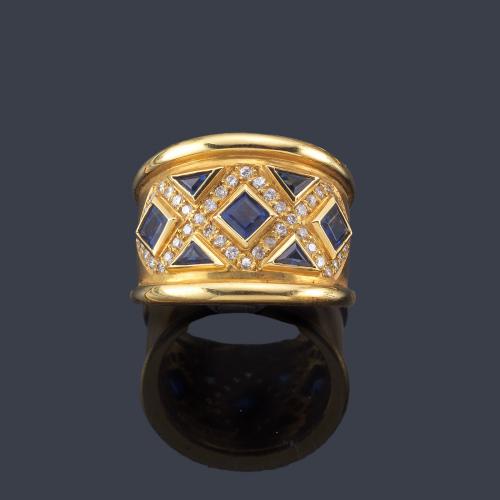  Anillo con diseño de damero con zafiros calibrados y brillantitos en montura de oro amarillo de 18K.
