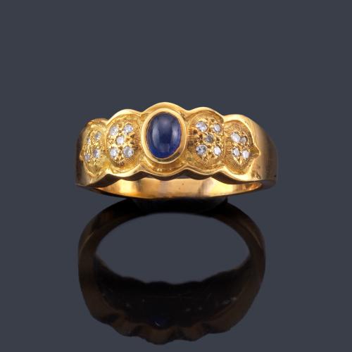  Anillo con zafiro talla cabujón y brillantes en ambos lados.