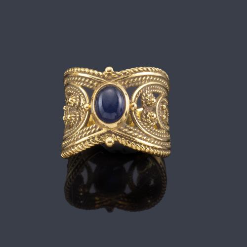  Anillo con zafiro talla cabujón en montura de oro amarillo de 18K decorado con esferillas.
