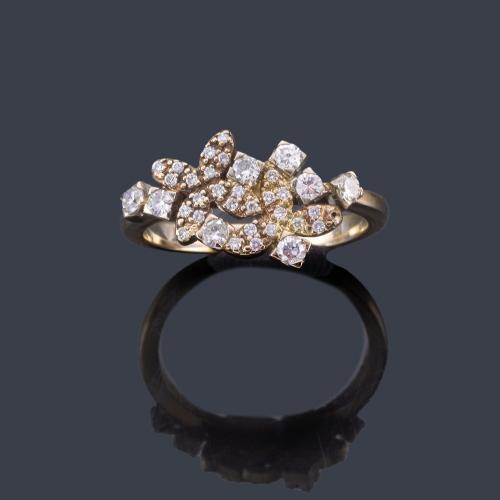  Anillo con dos motivos florales cuajados de diamantes talla brillante y sencilla, en montura de oro blanco de 18K.