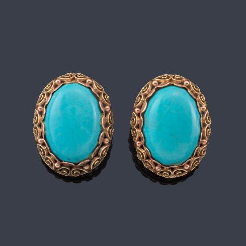 Lote 2474
Pendientes cortos con pareja de turquesas en cabujón con orla calada en montura de oro amarillo de 18K.