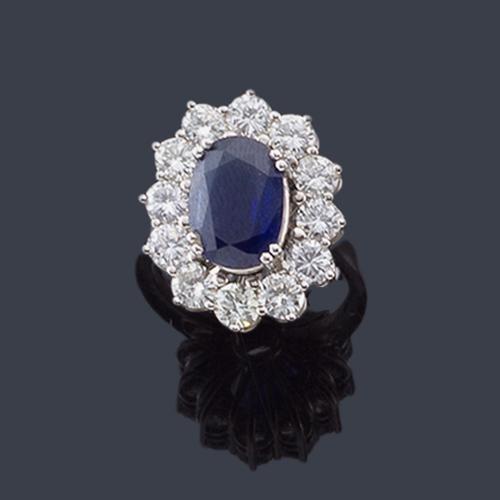  Anillo con zafiro talla oval de aprox. 3,00 ct con orla de brillantes de aprox. 1,20 ct en total.