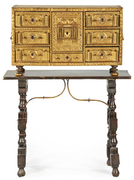  Bargueño sin tapa, presenta tres cajones a cada lado de una portada grande inscrita en un rectángulo, sobre un cajón más pequeño. Realizado en madera de nogal, tallada y dorada, con columnillas de hueso. España, finales S. XVII