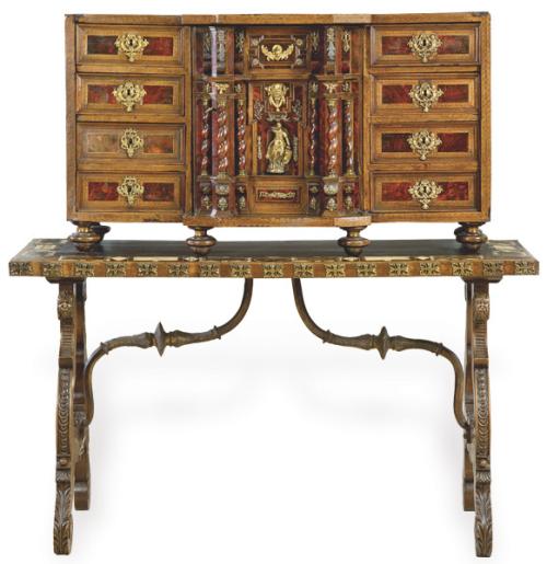 Lote 1116
Escritorio de influencia europea con cuatro cajones a cada lado de un cuerpo central sobresaliente en madera de nogal y placas de carey, con columnas salomónicas apoyado en patas de disco torneadas