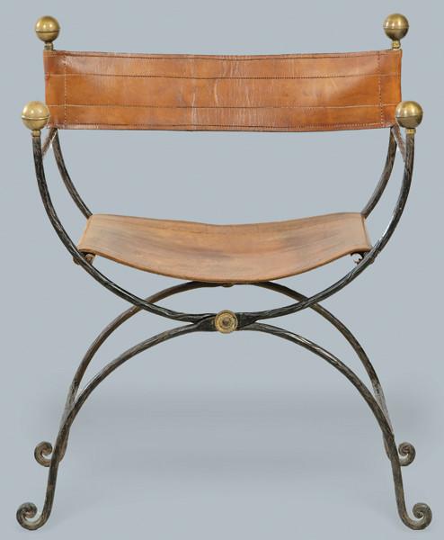  Silla de brazos tipo Savoranola, siguiendo la tipología italiana del S. XVII, con estructura de hierro, con remates en forma de toupie en latón, respaldo y asiento en cuero. S. XX