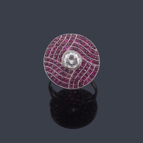  Anillo con diseño circular con brillante central de aprox. 0,65 ct con bandas onduladas de rubíes calibrados de aprox. 4,11 ct en total, en montura de oro blanco de 18K.