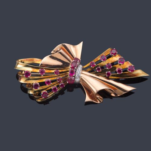 Lote 2117
Broche retro en forma de lazada con rubíes sintéticos y banda central de diamantes en montura de oro rosa de 18K. Años '40.