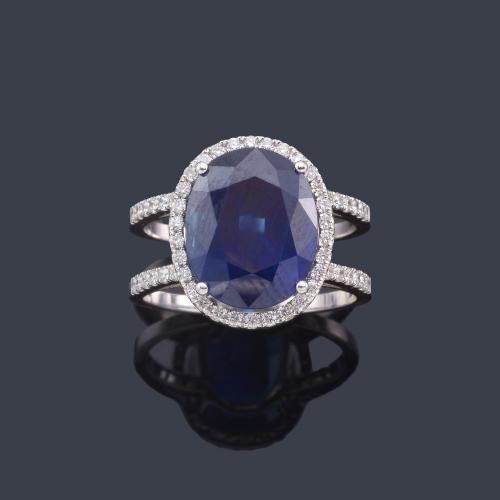  Anillo con zafiro talla oval de aprox. 7,56 ct con orla y brazos de brillantes de aprox. 0,50 ct en total. Certificado Gemacyt.