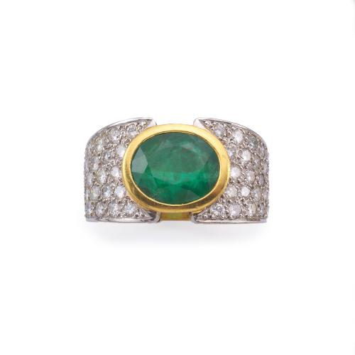  Anillo ancho en oro de dos colores (18K), con esmeralda central de aprox. 3,30 ct y brazos en pavé de brillantes.