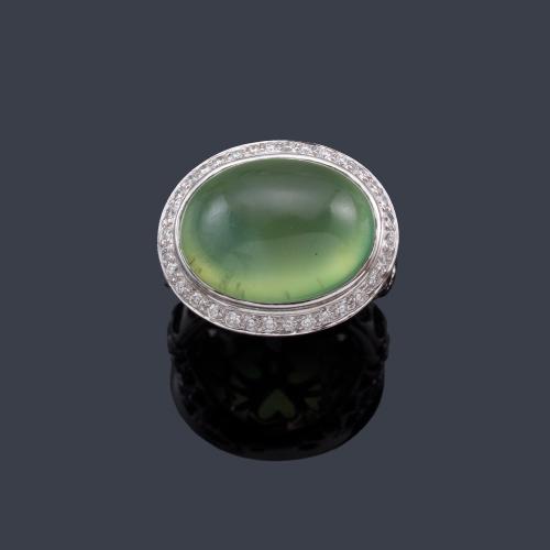  Anillo con prenhita talla cabujón con orla de brillantes en montura calada de oro blanco de 18K.
